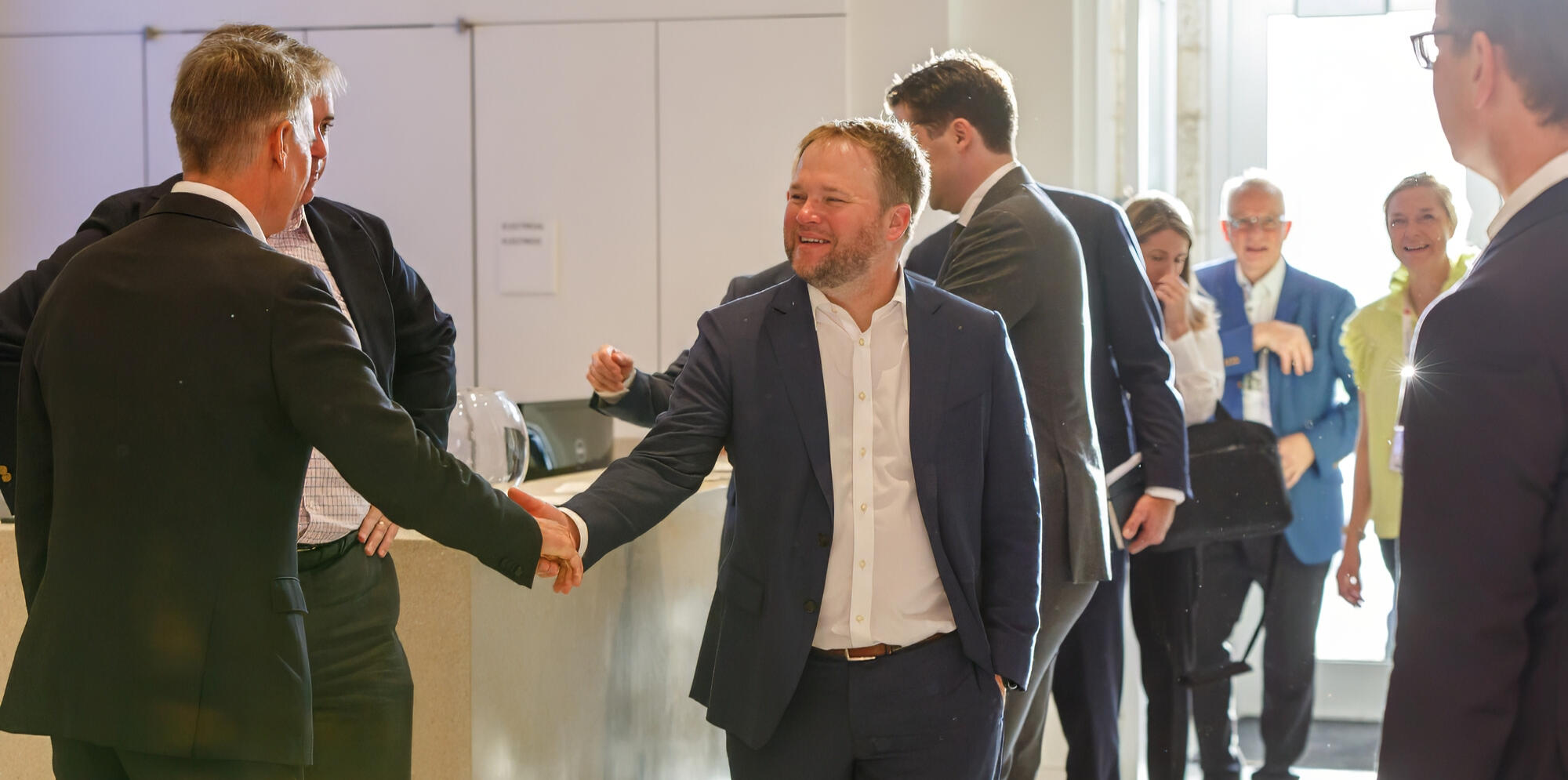 Business professionals warmly greeting each other during a networking session at a corporate event in NYC
